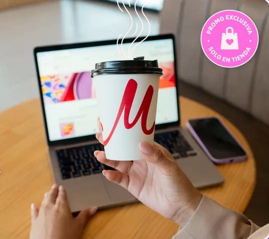Vaso de café de Madame Crêpe junto a una laptop